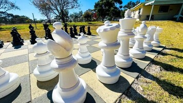 A large outdoor chessboard with oversized chess pieces.