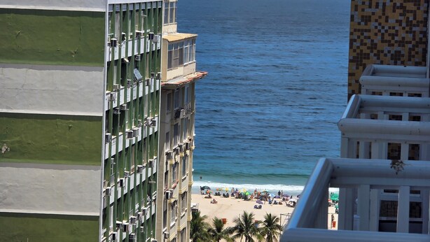 A high-rise building with multiple balconies overlooking a beach. - Copacabana 4 bedrooms (2 suites) with side sea and mountain views (Rio de Janeiro)