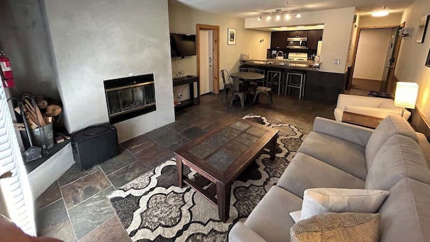 Una sala de estar con chimenea, comedor y cocina.