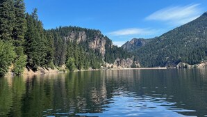 A calm lake with dense forested hills in the background. - Wilderness, wildlife, and fishing cabin - The Ponderosa at Alta Ranch (Darby)