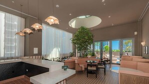 A modern interior with a kitchen, seating area, and a large window providing a view of the outdoors. - Crosby 31 | Signature Skyline Residence (Miami)