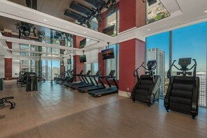 Ein modernes Fitnessstudio mit Laufbändern, Crosstrainern und Krafttrainingsgeräten.
