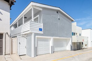 Um edifício de dois andares com varanda, garagem e céu limpo.