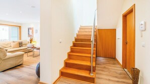 A staircase with wooden steps and a metal railing, leading to a wooden door. - Furadouro Holiday Villa | Pool, Tennis & Garden (Ovar)