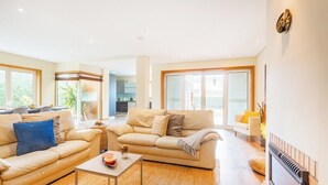 A modern living room with a sofa, coffee table, and a fireplace. - Furadouro Holiday Villa | Pool, Tennis & Garden (Ovar)