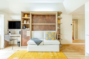 Ein modernes Wohnzimmer mit Sofa, Couchtisch, Fernseher und einer integrierten Holzregalanlage.