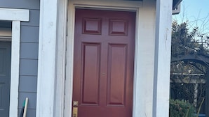 A red door with a doormat and a mailbox on the porch. - Cozy 1-bedroom studio above detached garage in serene Yountville (Yountville)