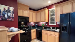 A kitchen with wooden cabinets, a black refrigerator, a stove, and a microwave. - Cozy 1-bedroom studio above detached garage in serene Yountville (Yountville)
