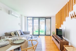 Ein modernes Wohnzimmer mit einer Couch, einem Esstisch und einer TV-Kommode.