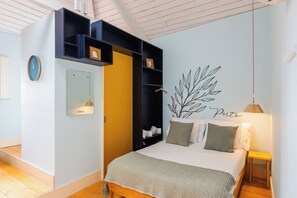 A bedroom with a bed, a wardrobe, a mirror, a wall decoration, and a bedside table. - Victoria Studios 8 @ Clérigos (Porto)