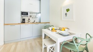 Eine moderne Küche mit Mikrowelle, Kaffeemaschine und einem Essbereich mit Tisch und Stühlen.