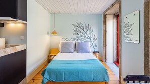 Ein Schlafzimmer mit Bett, Nachttisch, Lampe und Wanddeko.