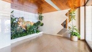 Ein modernes Interieur mit Holzboden, einer gefliesten Wand mit dekorativer Reliefstruktur und einem Blumentopf.