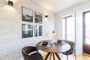 Ein Essbereich mit einem runden Tisch, zwei Stühlen und Bilderrahmen an der Wand.