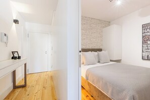 Ein Schlafzimmer mit Bett, Nachttisch, Spiegel und Wand mit motivierendem Zitat.