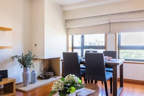 A dining area with a table, chairs, a vase with flowers, and a fireplace. - Foz Premium Retreat with Parking (Porto)