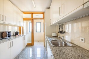 A modern kitchen with white cabinets, granite countertops, a stainless steel sink, and a toaster. - Foz Premium Retreat with Parking (Porto)