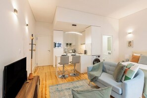 A modern apartment with a living room, kitchen, and dining area. - Sol Downtown Studio with Juliet Balcony (Porto)