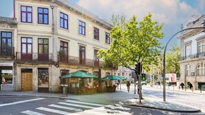 A street with a café, a crosswalk, and buildings with balconies. - Casa Fernando @ Trindade (Porto)