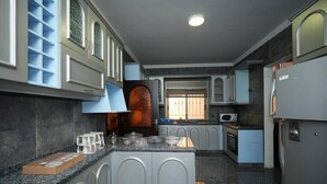 A modern kitchen with grey cabinets, a granite countertop, and stainless steel appliances. - Sahel Alma Luxurious 3 Bdrm With a Garden (Jounieh)