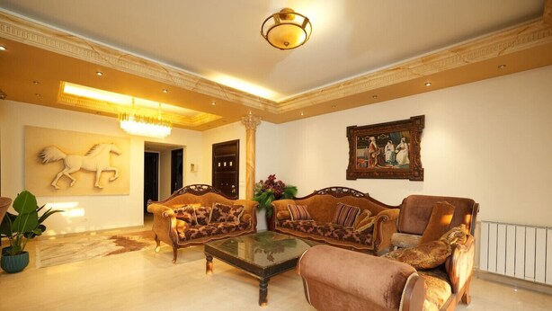 A spacious living room with a large sofa set, a coffee table, and a chandelier. - Sahel Alma Luxurious 3 Bdrm With a Garden (Jounieh)