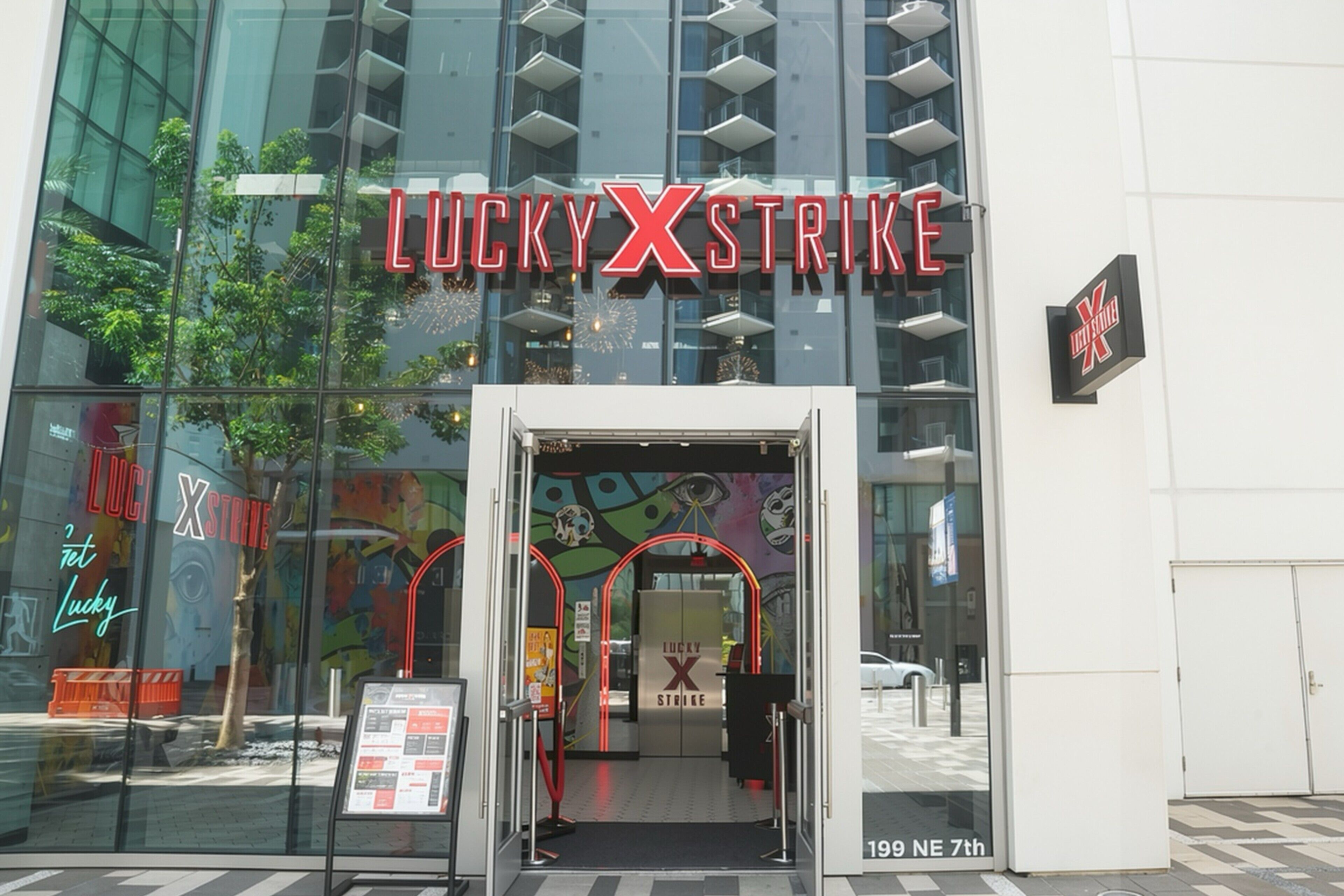 Der Eingang eines Gebäudes mit Glasfassade und einem Schild mit der Aufschrift 'LUCKY XSTRIKE'.