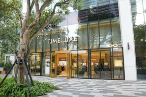 A modern building with the sign 'TIMELUXE' indicating a store or business establishment. - 2BR/2BA Palm Oasis at The Crosby (Miami)