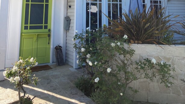 Uma casa de dois andares com porta verde e o número 146 na fachada.
