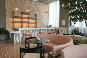A modern interior with a bar area, seating, and a large potted plant. - Stylish Minimalist 1BR in The Crosby (Miami)