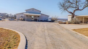 A residential property with a large house, a driveway, and a tree.