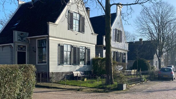 A traditional two-story house with a steep gabled roof, a front porch, and a fenced yard. - 2 bedroom cozy apartment in Broek in Waterland (Broek in Waterland)