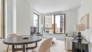 Un salon moderne avec une table à manger ronde, un canapé et une lampe.
