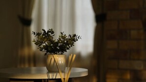 A round table with a potted plant, a candle, and a glass container with sticks. - Spacious 5BR Family Home with Pool in Robertson (Robertson)