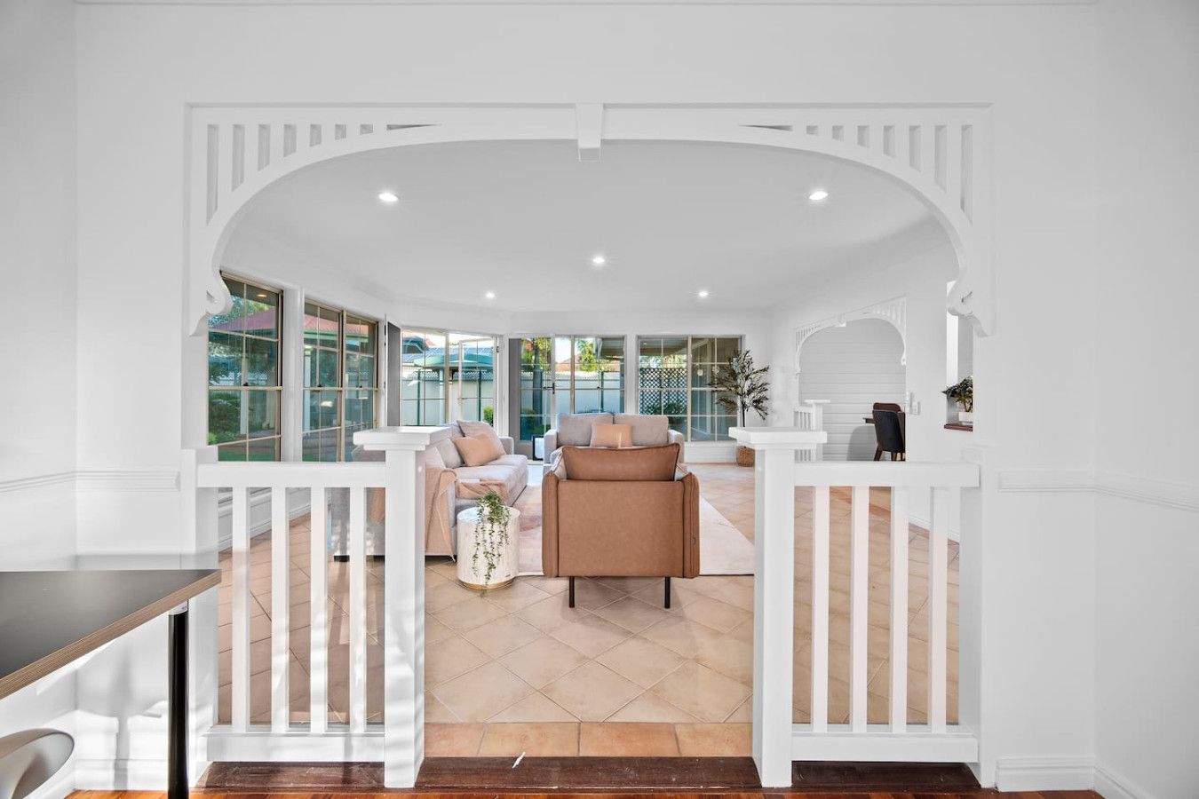 A spacious living area with a white railing, a sofa, and a coffee table.