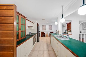 Eine moderne Küche mit weißen Schränken, grünen Arbeitsplatten und einer zentralen Kochinsel mit Spüle.