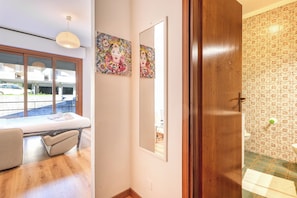 A bedroom with a bed, a bedside table, a mirror, and a window. - Casa Miraflores - Sanremo WiFi A/C, Sanremo, Italy (Sanremo)