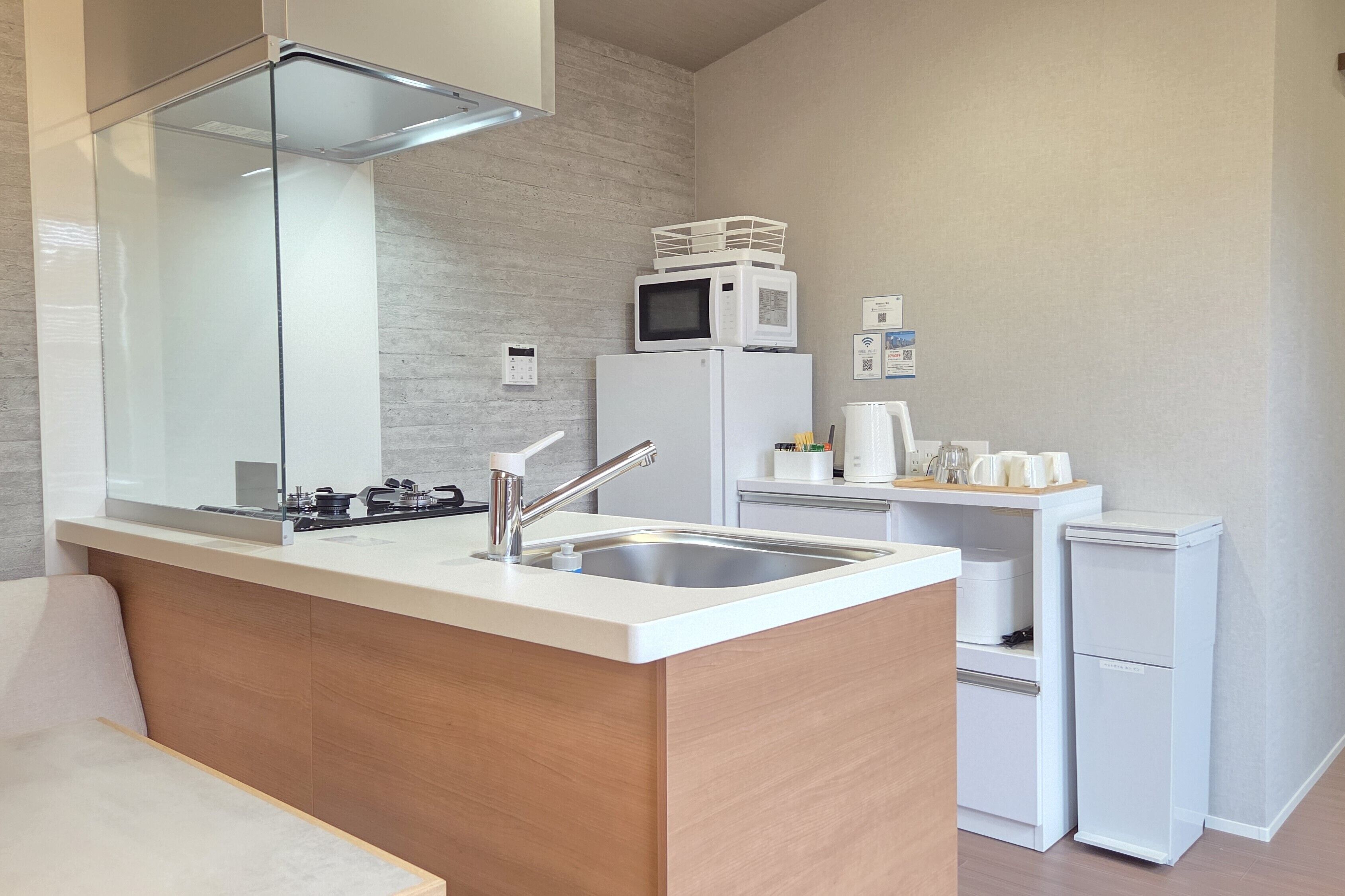A modern kitchen with a built-in island, stainless steel sink, and white appliances.
