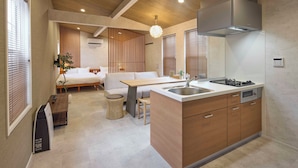 A modern kitchen with a central island, wooden cabinets, and a built-in stove. - Solana Smart INN Fuji Gotenba  (Gotemba)