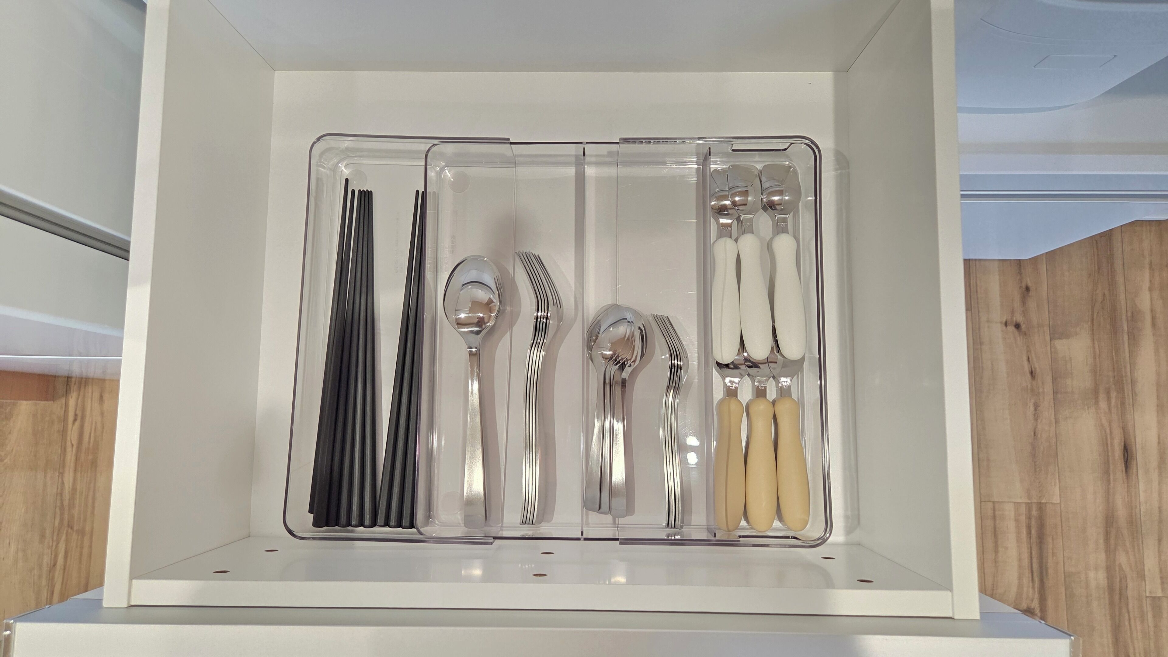 A storage box containing various utensils including forks, spoons, and knives.
