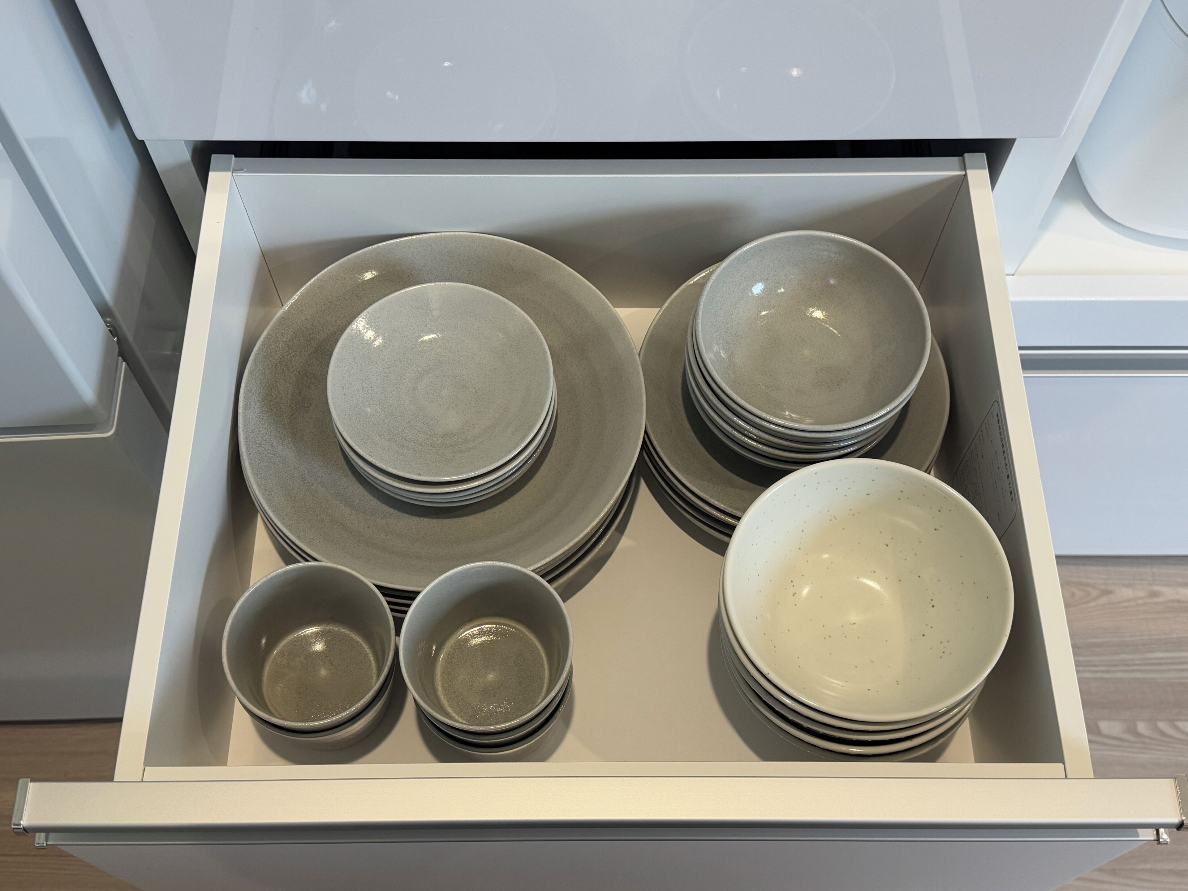 A drawer containing various plates and bowls.