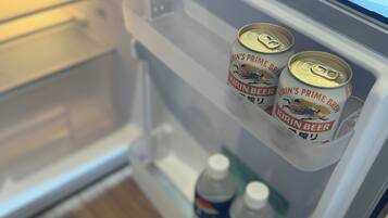 A refrigerator with two Kirin beer cans and two bottles of Pepsi.