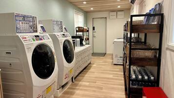 A laundry facility with multiple washing machines and a water dispenser.