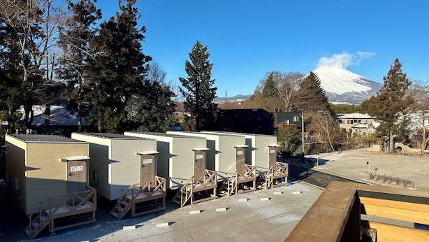 Portable restrooms with wooden steps and a view of a snowy mountain in the background. - Solana Smart INN Fuji Gotenba  (Gotemba)