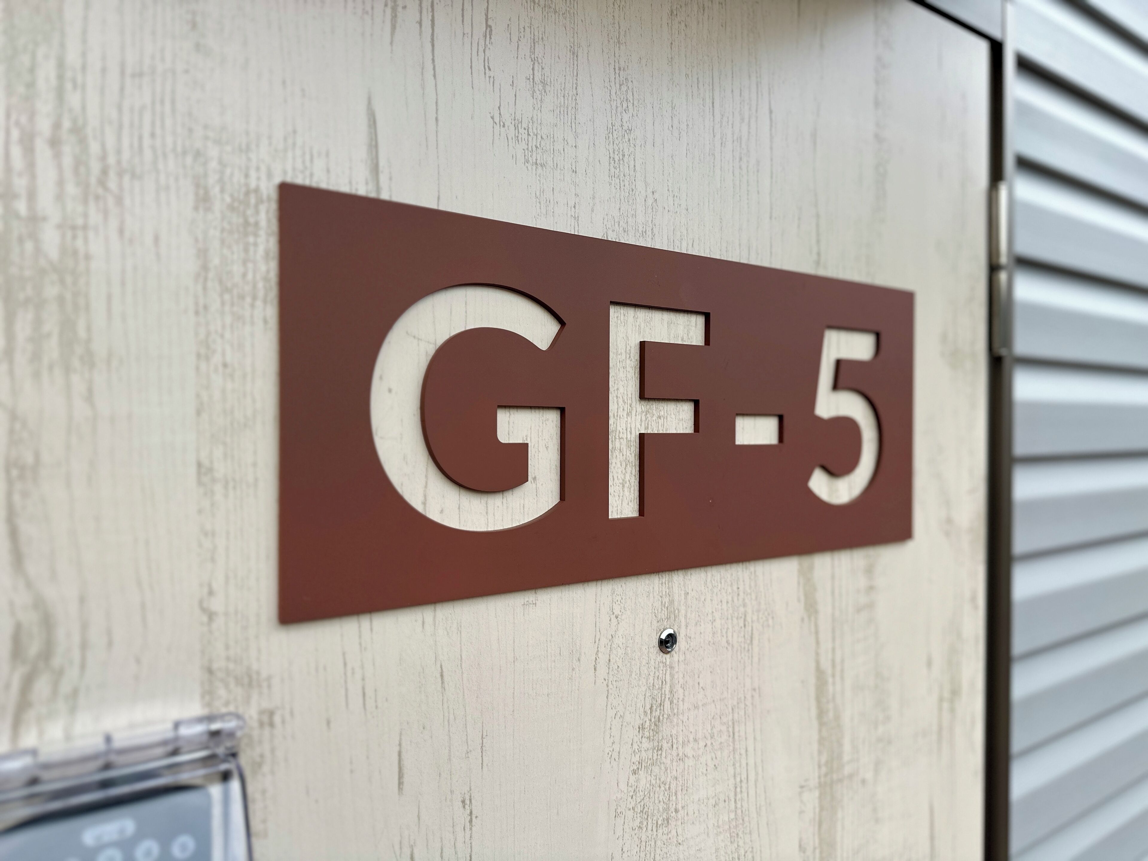 A sign with the text "GF-5" on a wooden door.