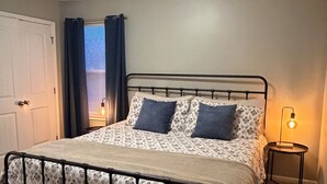 A bedroom with a bed, a ceiling fan, a window with curtains, and a bedside lamp. - Tremendous 3-bedroom townhome with close to Cave Hollow Park in Warrensburg (Warrensburg)