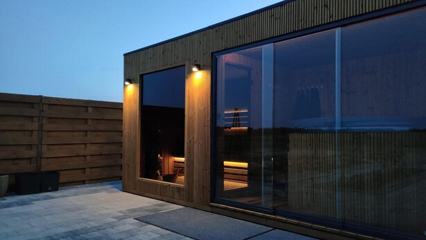 A modern building with large windows and a wooden exterior.