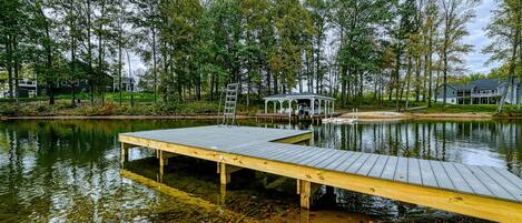 Waterfront - View from the water showing the dock platform and walkway leading up to the home through the tree-lined property.