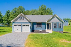 Exterior - Blue craftsman-style ranch with a two-car garage, gabled entry, and a welcoming gravel driveway surrounded by green lawn. - Lakefront Luxury - Beach, Dock, Deck @ Lake Anna (Mineral)
