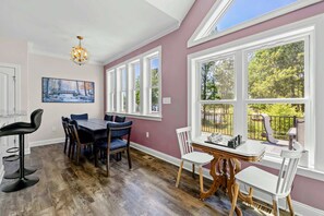 A dining area with a table, chairs, and a chandelier.