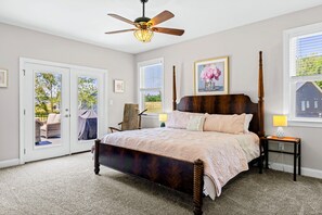 Primary Suite - Carved wood four-poster bed, plush blush bedding, and a quiet seating nook by the French doors. - Lakefront Luxury - Beach, Dock, Deck @ Lake Anna (Mineral)
